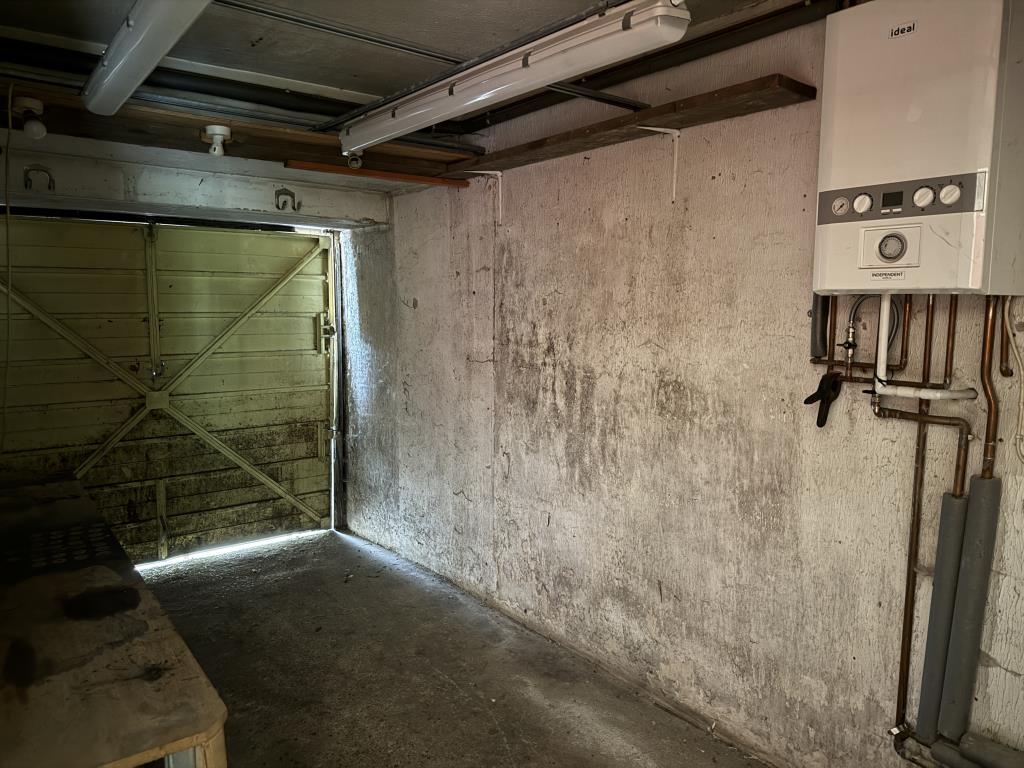 Lot: 73 - THREE-BEDROOM SEMI-DETACHED HOUSE WITH GARAGE IN NEED OF IMPROVEMENT - Internal view of garage with wall mounted boiler